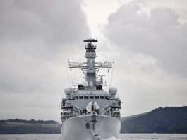 A grey Royal Navy Type 23 frigate sailing head-on towards the camera under a cloudy sky, file photograph