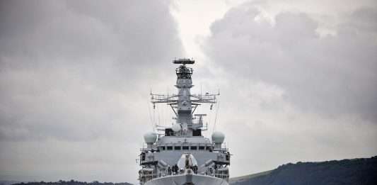A grey Royal Navy Type 23 frigate sailing head-on towards the camera under a cloudy sky, file photograph