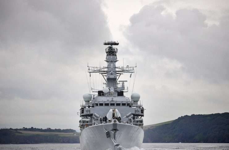 A grey Royal Navy Type 23 frigate sailing head-on towards the camera under a cloudy sky, file photograph