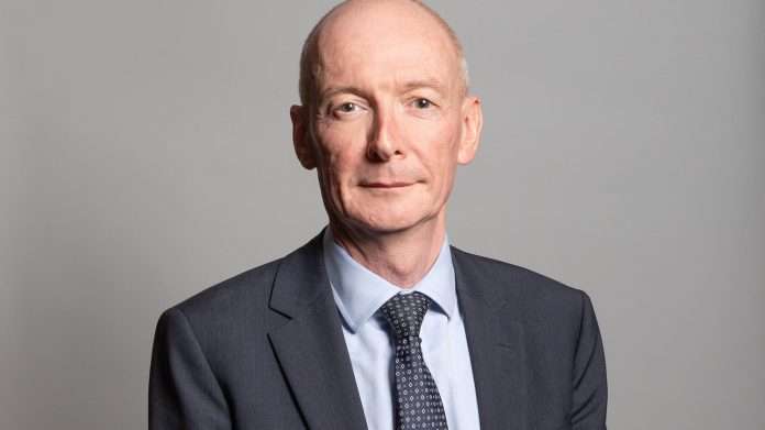 Pat McFadden, Work and Pensions Secretary, in a dark suit and patterned tie against a grey background